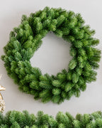 24 in Royal Fir artificial Christmas wreath, unlit, above a matching garland on a white wall