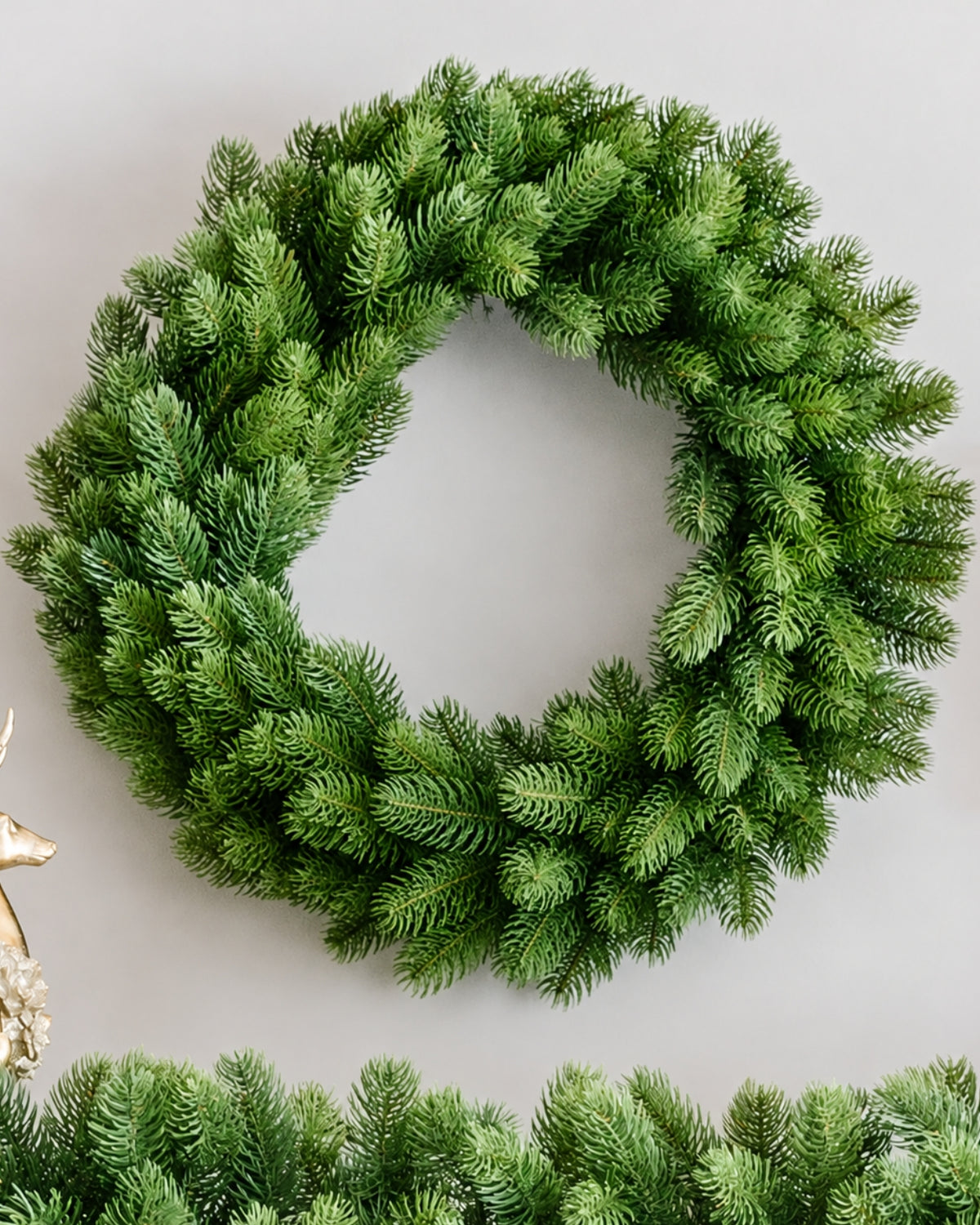 24 in Royal Fir artificial Christmas wreath, unlit, above a matching garland on a white wall