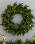 28 in Alpine Fir artificial Christmas wreath, glowing with warm white LED lights, above a mantel garland with gold reindeer