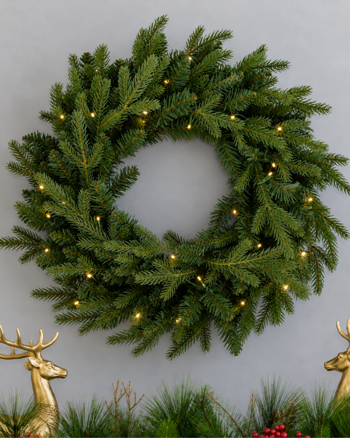 28 in Alpine Fir artificial Christmas wreath, glowing with warm white LED lights, above a mantel garland with gold reindeer