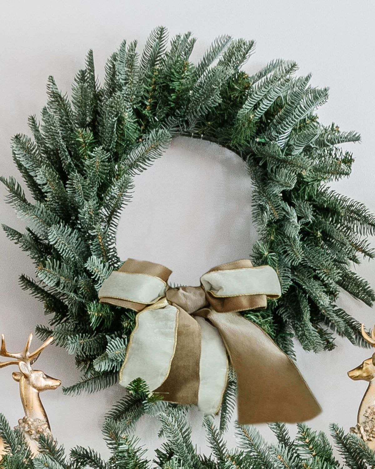 28 in King Noble Fir artificial Christmas wreath, pre-lit with warm white LED lights, with a gold ribbon bow