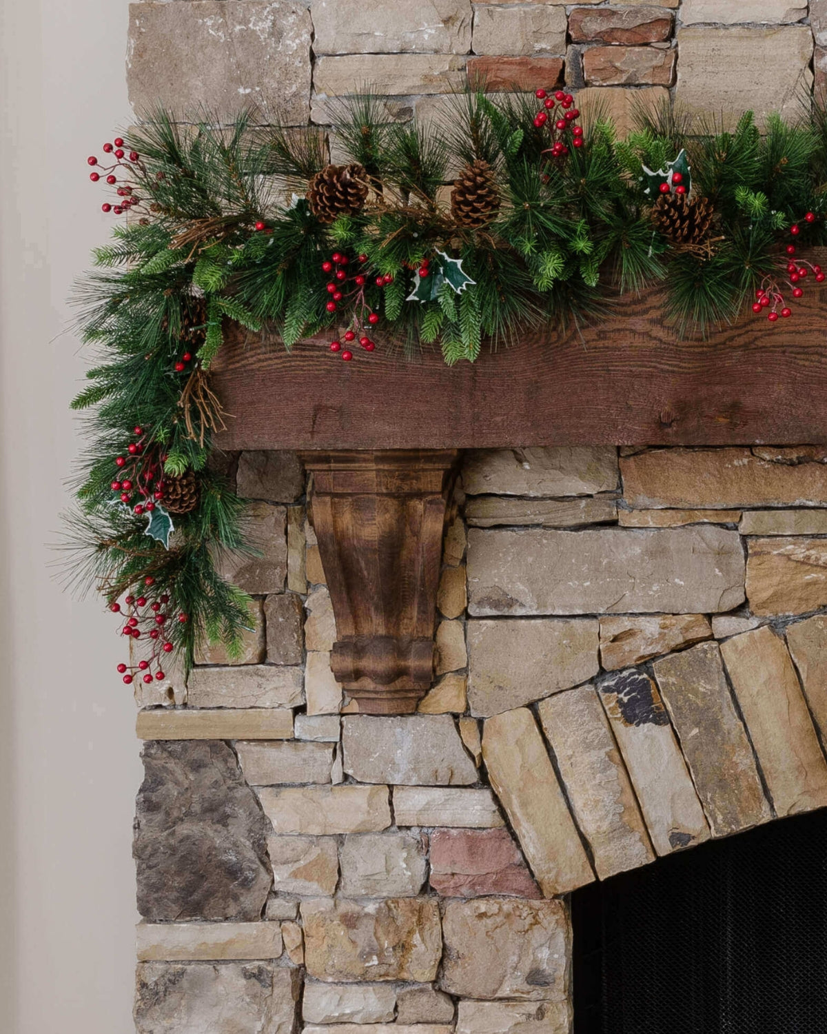 9 ft Redwood artificial Christmas garland, pre-lit with warm white LED lights, draped over a stone fireplace mantel