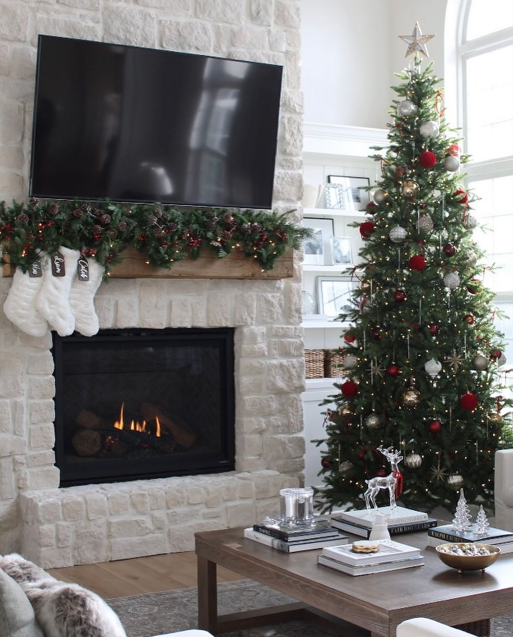 Alpine Fir Slim artificial Christmas tree, decorated beside a white stone fireplace in a living room