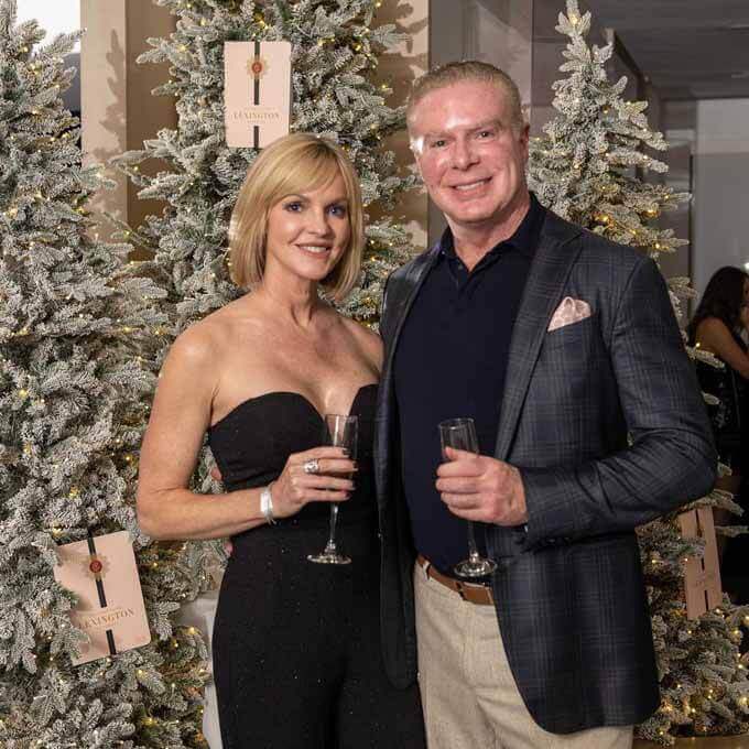 Couple toasting with champagne beside flocked trees, King of Christmas customer photo by @tsglexington