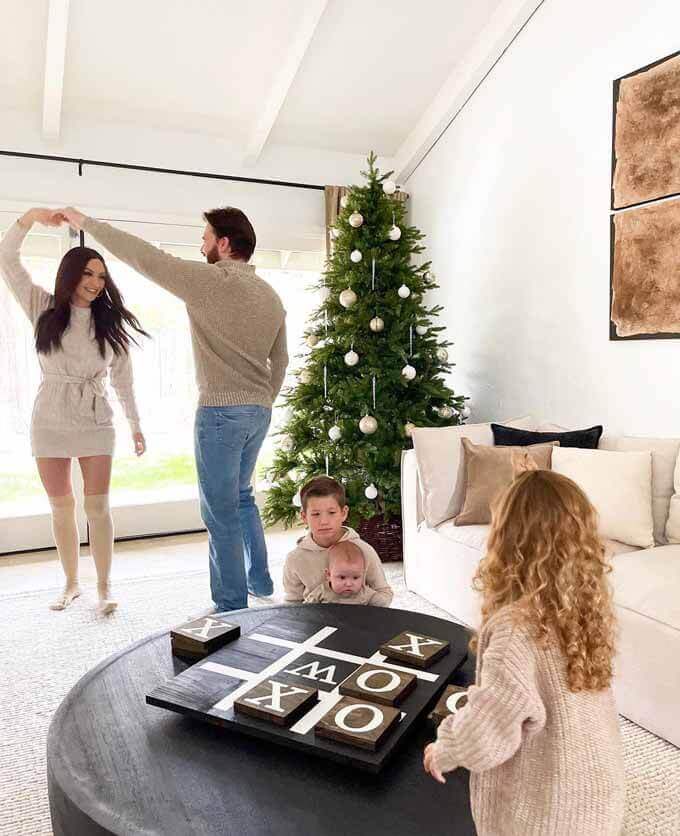 Family dancing in a living room with a green tree, King of Christmas customer photo by @sommerwhiteinteriors