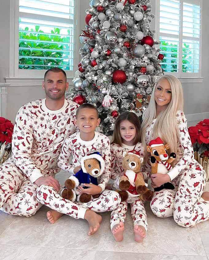 Family in matching pajamas beside a flocked tree, King of Christmas customer photo by @teatherallison