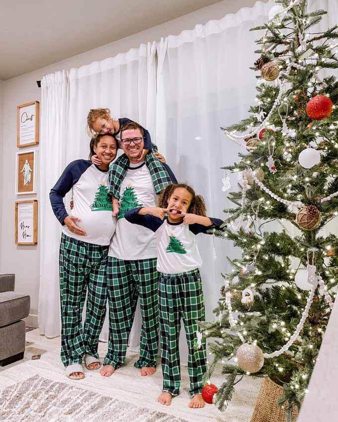 Family in plaid pajamas beside a decorated tree, King of Christmas customer photo by @patyharmon