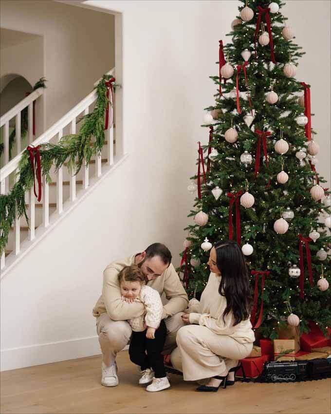 Mother and child by a tree beside a garland staircase, King of Christmas customer photo by @elyadangelo