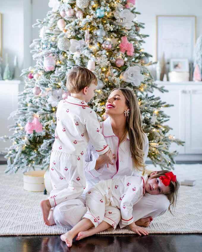 Mother and child in white pajamas by a flocked tree with pink ornaments, King of Christmas customer photo by @taraturnure