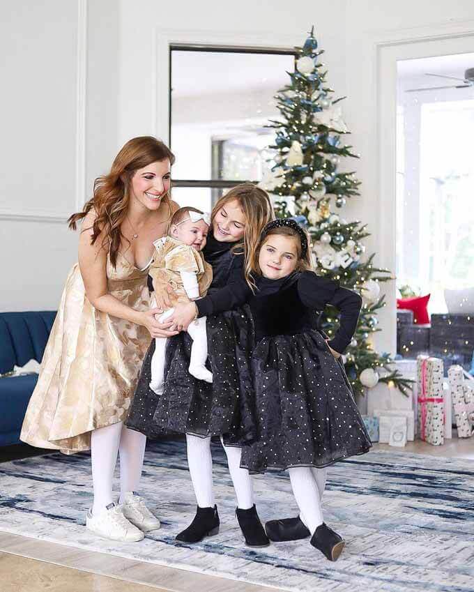Mother and daughters in dresses beside a tree, King of Christmas customer photo by @laur_diamantas