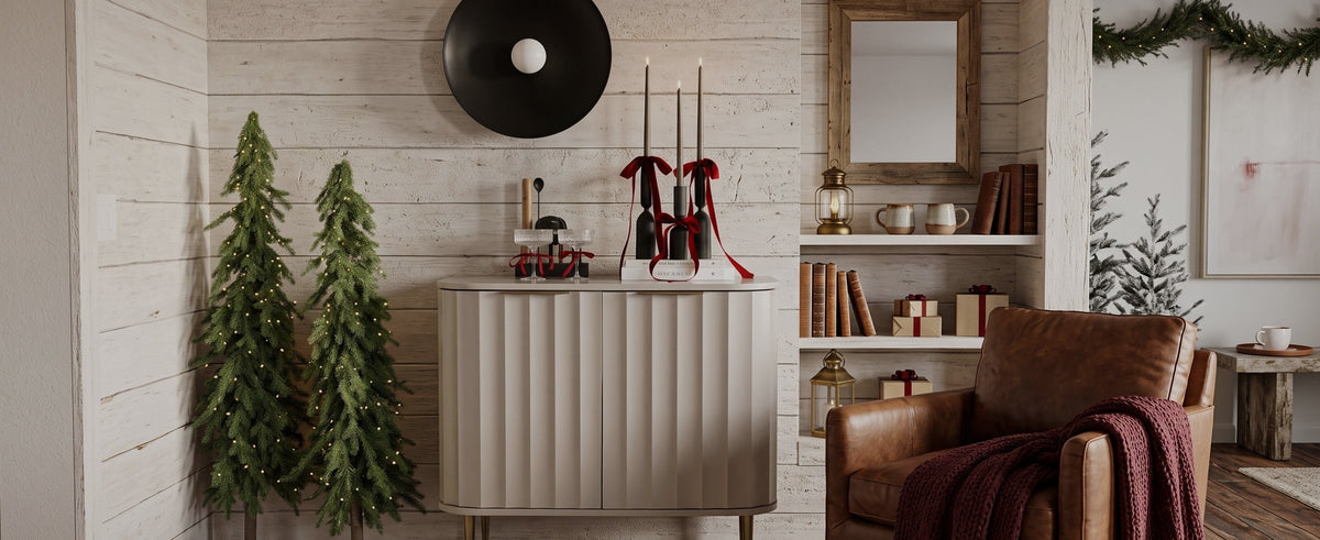 Two slim Windsor artificial Christmas trees beside a console in a shiplap room