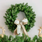 24 in Cypress Spruce artificial Christmas wreath, unlit, with a cream ribbon bow between gold reindeer