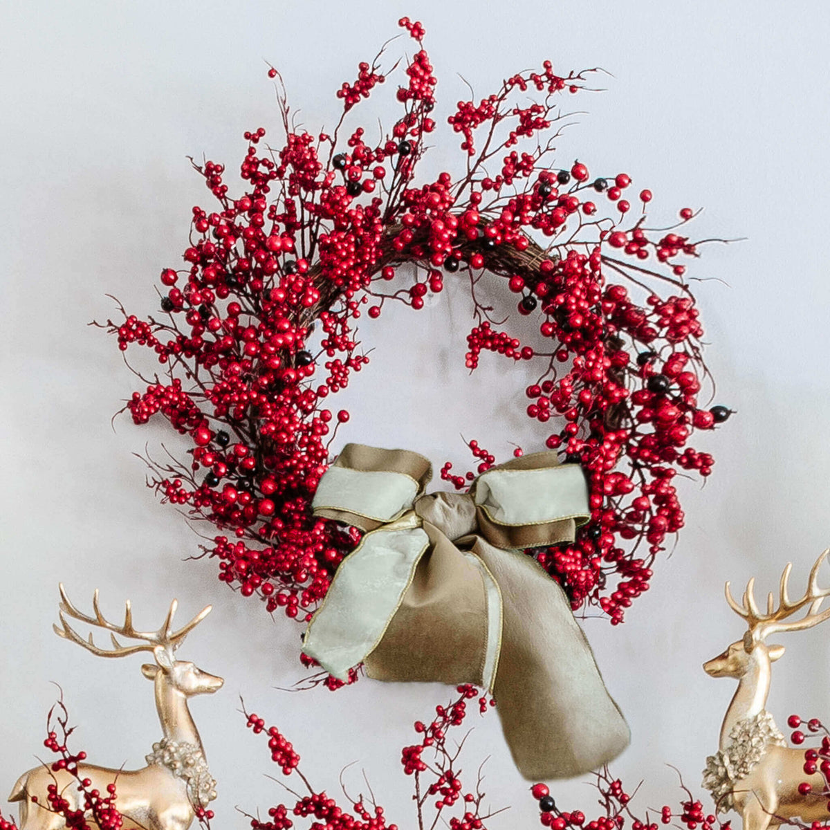 24 in Red Berry artificial Christmas wreath, unlit, with a cream ribbon bow between gold reindeer