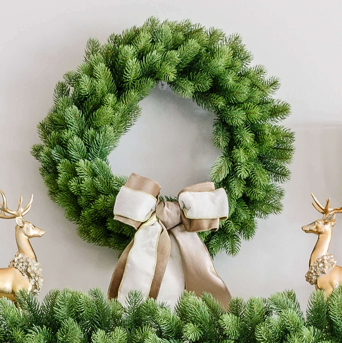 24 in Royal Fir artificial Christmas wreath, unlit, with a cream ribbon bow between gold reindeer