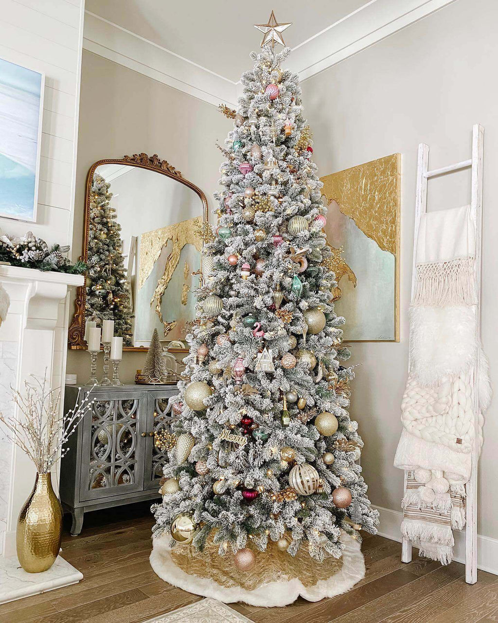 7.5 ft King Flock artificial Christmas tree, pre-lit with warm white LED lights, decorated with blush ornaments beside a mirror and blanket ladder