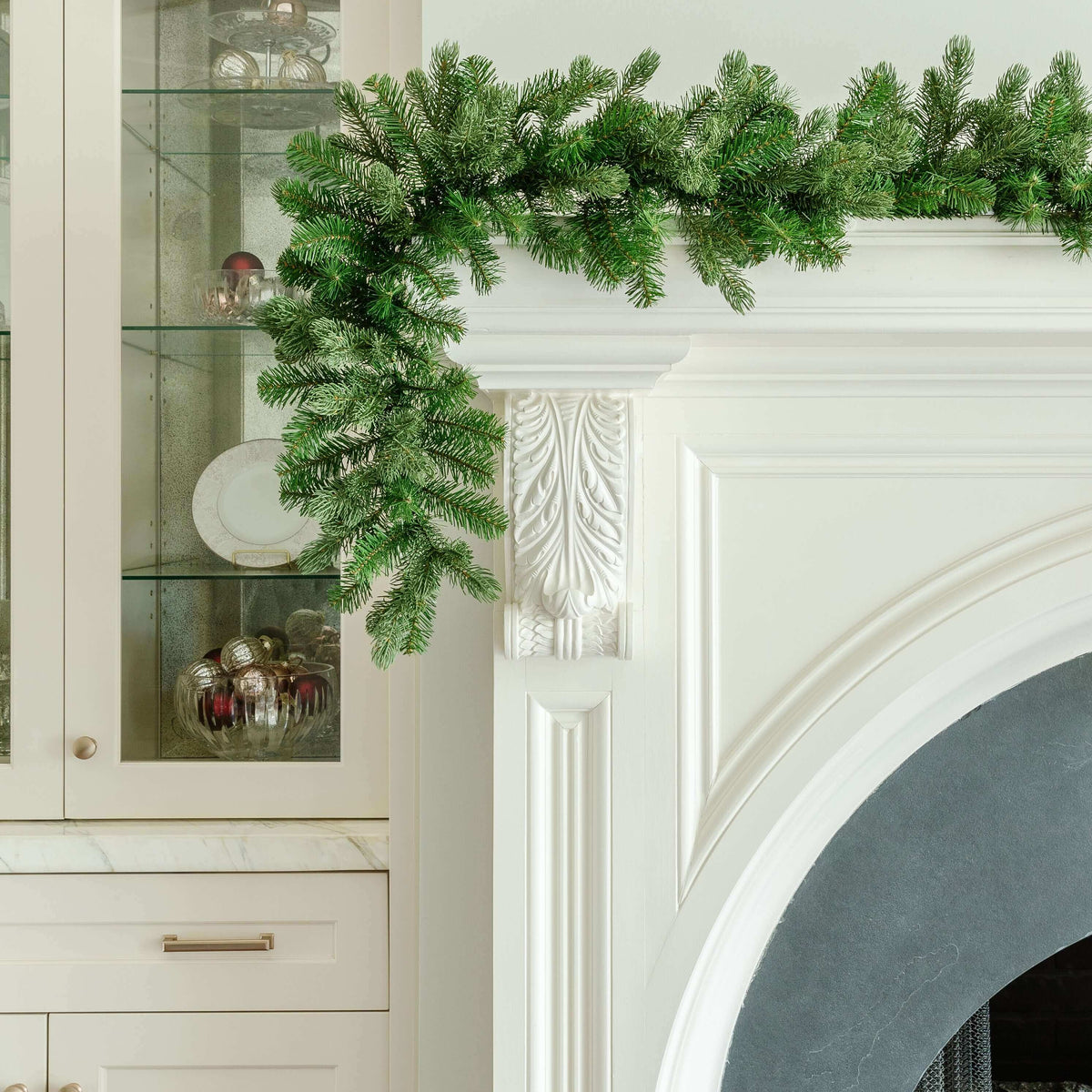 9 ft Cypress Spruce artificial Christmas garland, pre-lit with warm white LED lights, draped over a white fireplace mantel