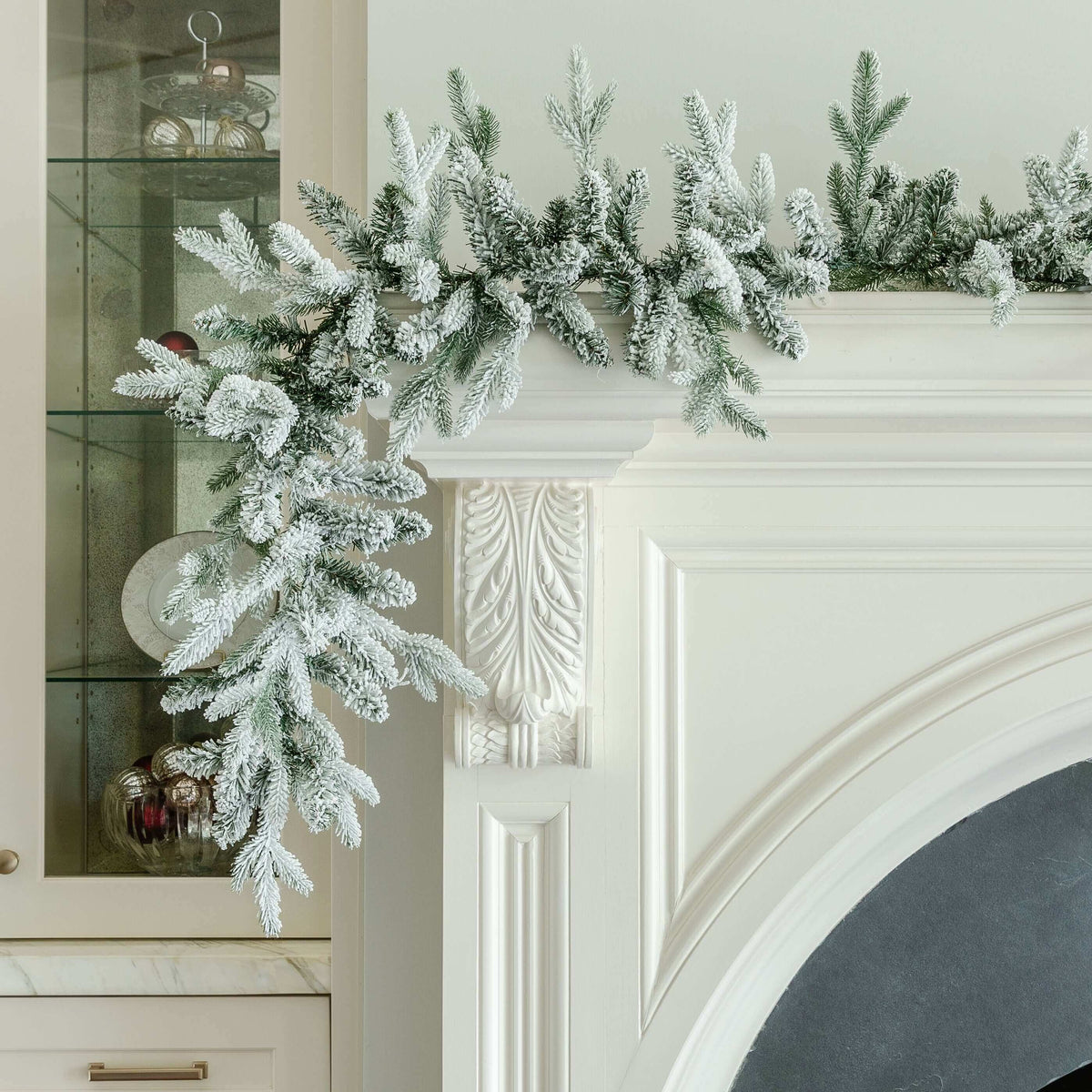 Queen Flock artificial Christmas garland draped over a white fireplace mantel