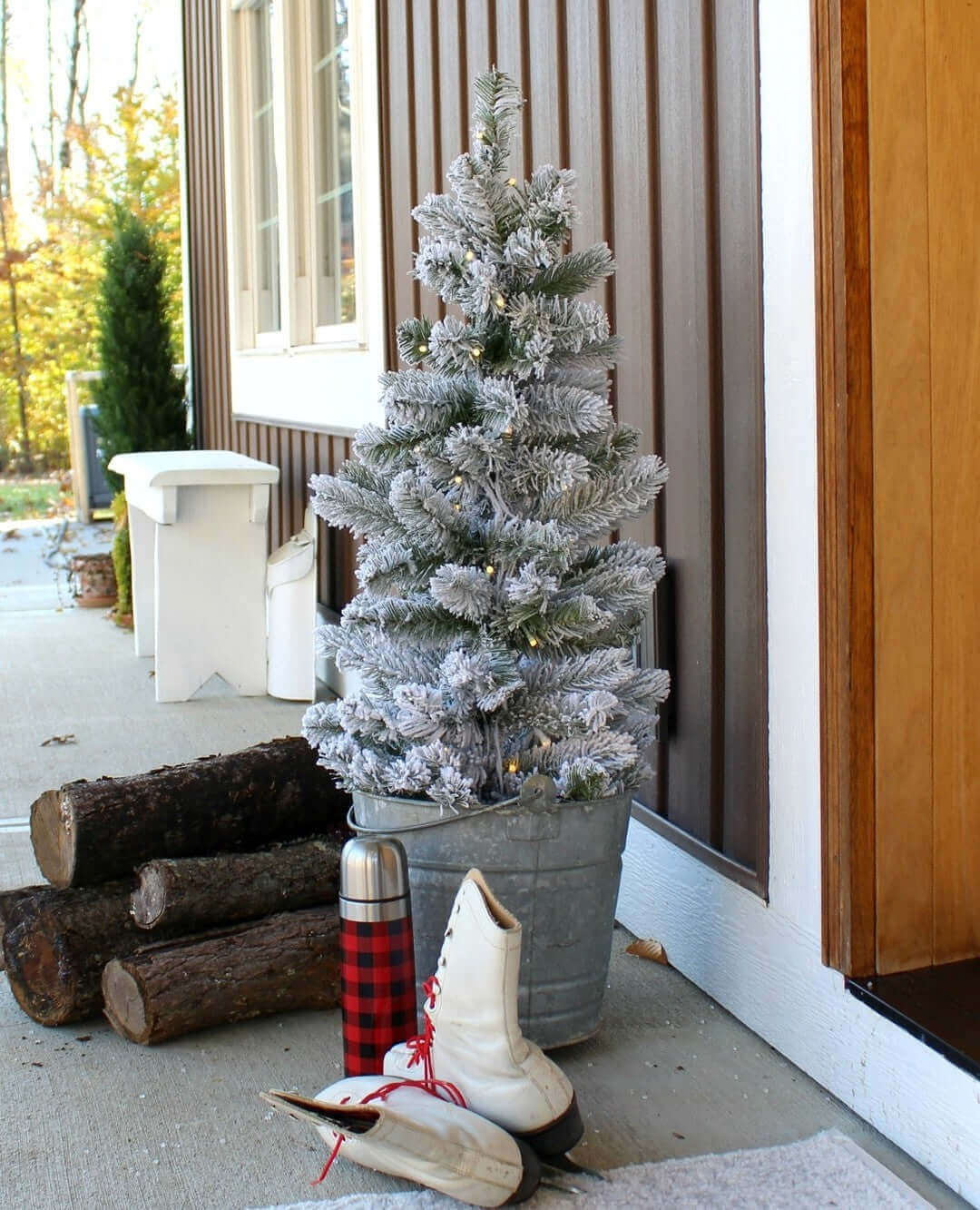 A flocked tabletop Christmas tree used as outdoor decor. 