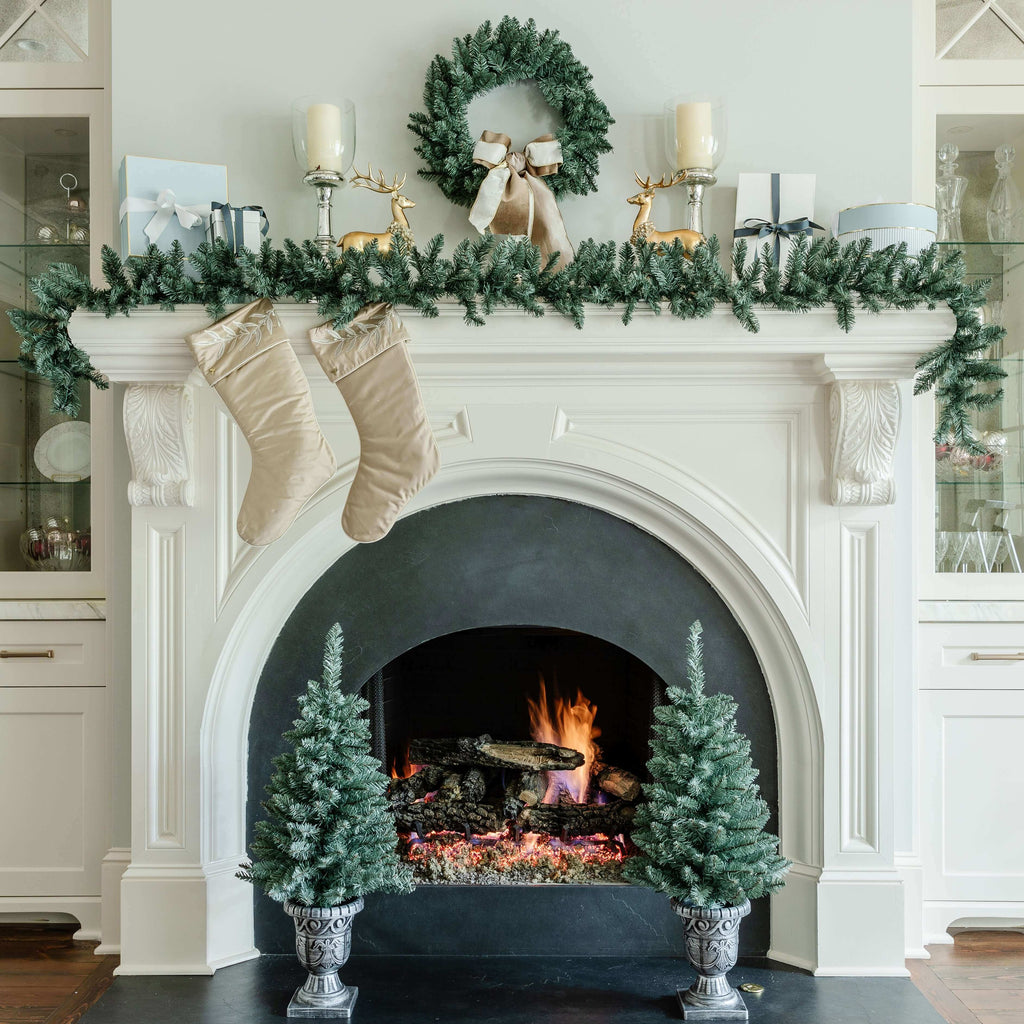Tribeca Blue Spruce wreath, garland and tabletop trees on a white fireplace with stockings